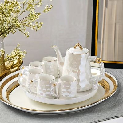 Une tasse de café en céramique rose avec soucoupe et tasse de thé en bambou