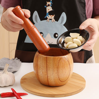 Mortier et pâté de bambou à la main pour le broyage des herbes d'ail Noix