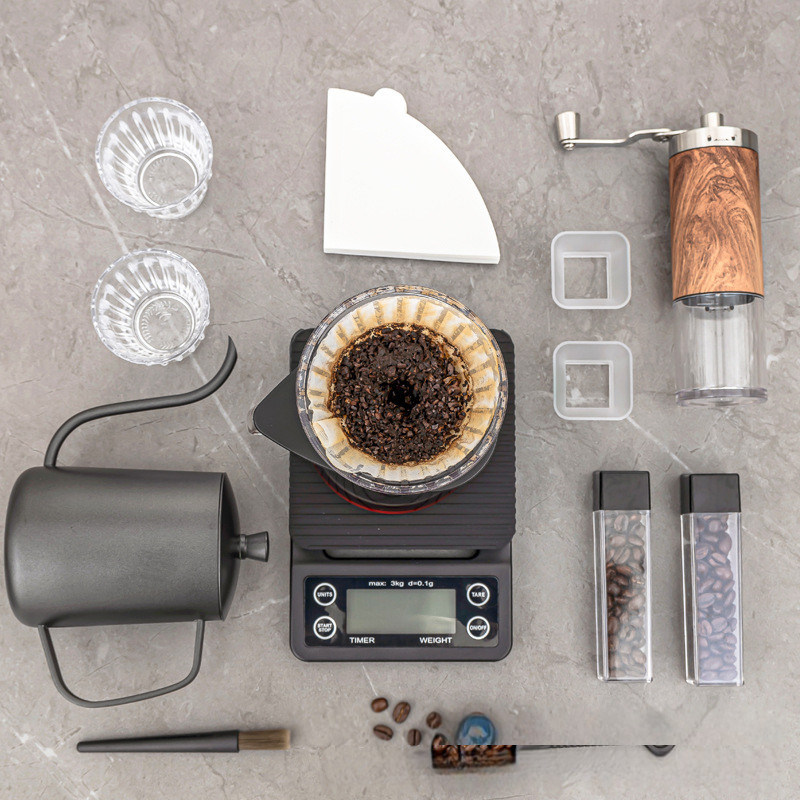 Les amateurs de café ont un ensemble de démarrage de style classique avec un broyeur, une casserole et des ustensiles.